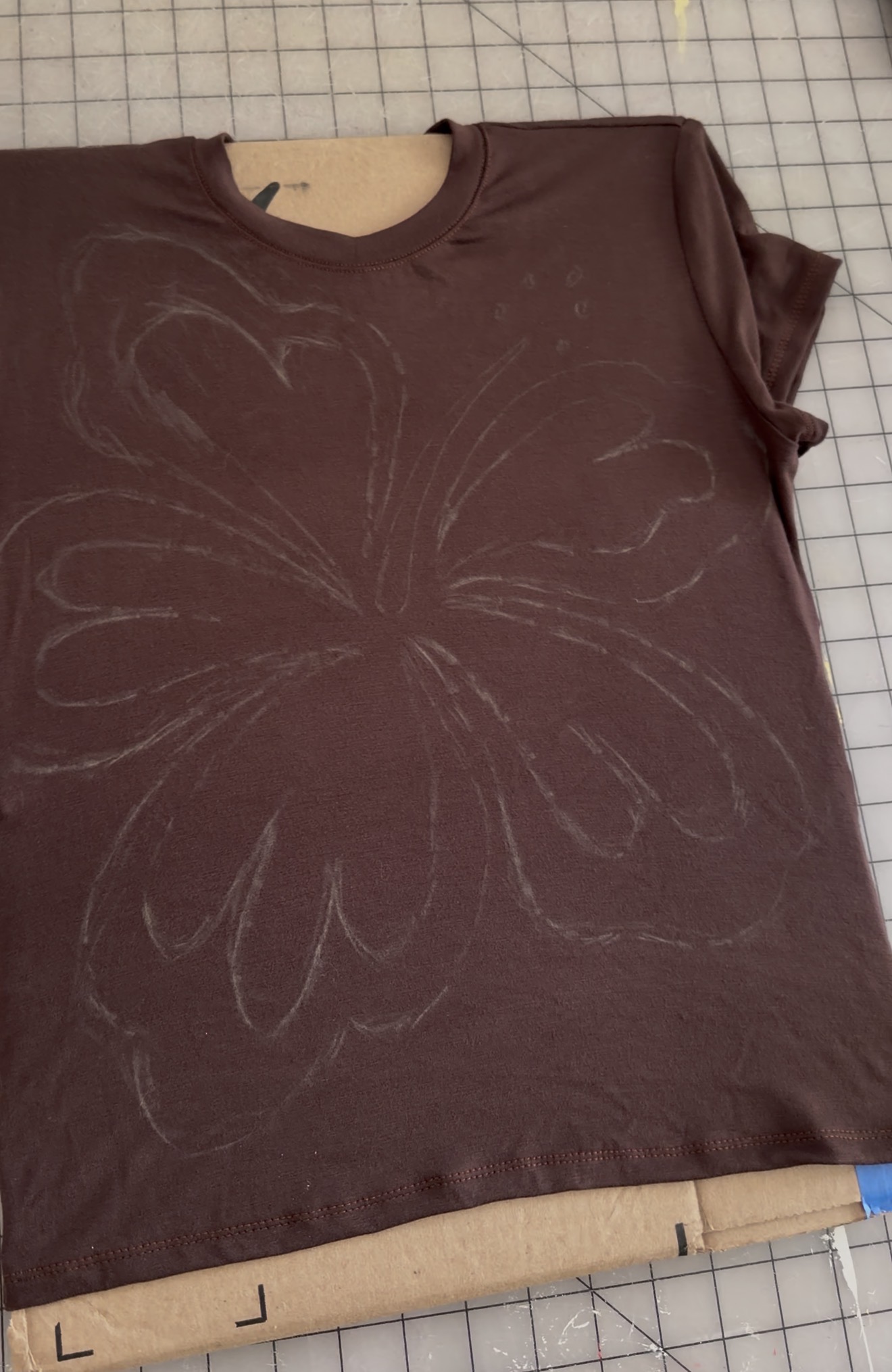 Rhinestone Baby Tee Tutorial Cardboard acting as a barrier between the fabric layers of the tee shirt.