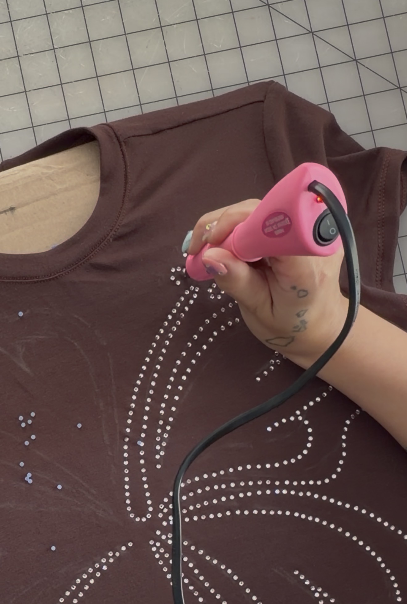 Rhinestone Baby Tee Tutorial rhinestones being hotfixed with hot fix tool